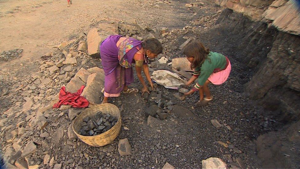 Two little girls working at a coal mine in India