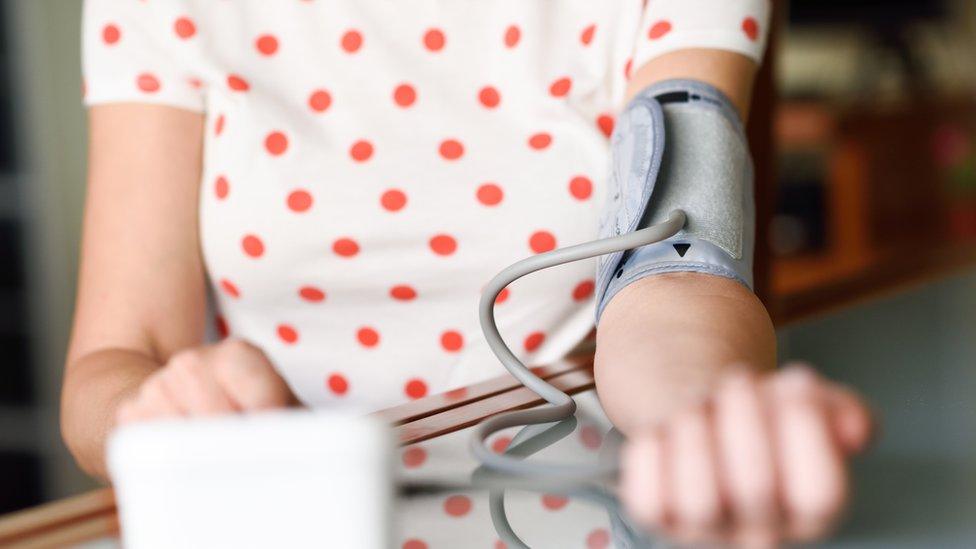 Woman taking her blood pressure at home