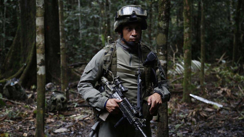 Anti-narcotics police officer stands guard next to an illegal cocaine lab in Calamar, Guaviare state, Colombia, Tuesday, Aug. 2, 2016