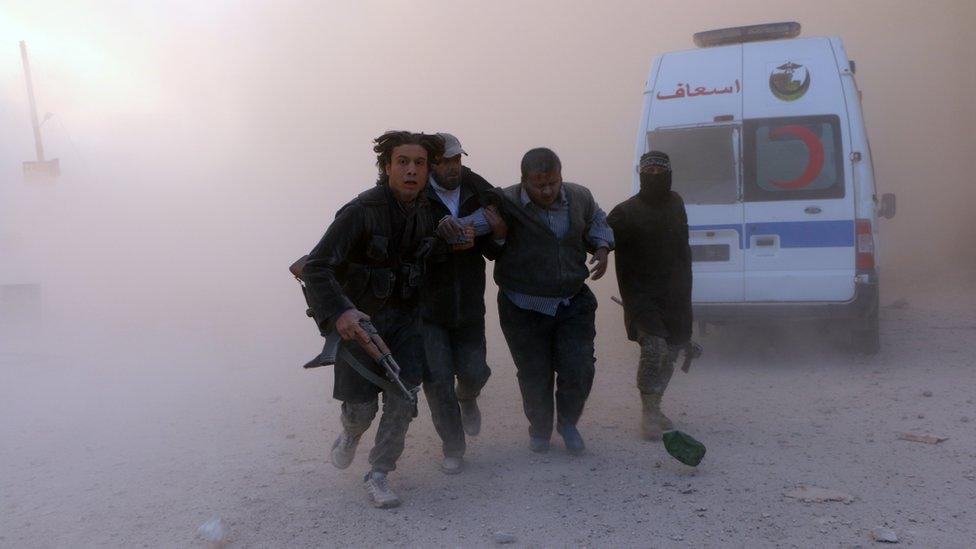 Fighters from the al-Qaeda group in Syria, Jabhat al-Nusra help a wounded man following a reported barrel bomb attack by government forces in the northern Syrian city of Aleppo on November 6, 2014.