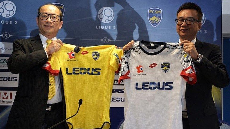 Li Wing-Sang, CEO of Hong-Kong based lighting company Ledus, and financial director Chi Hung Chiu show the new jerseys of Sochaux's football club