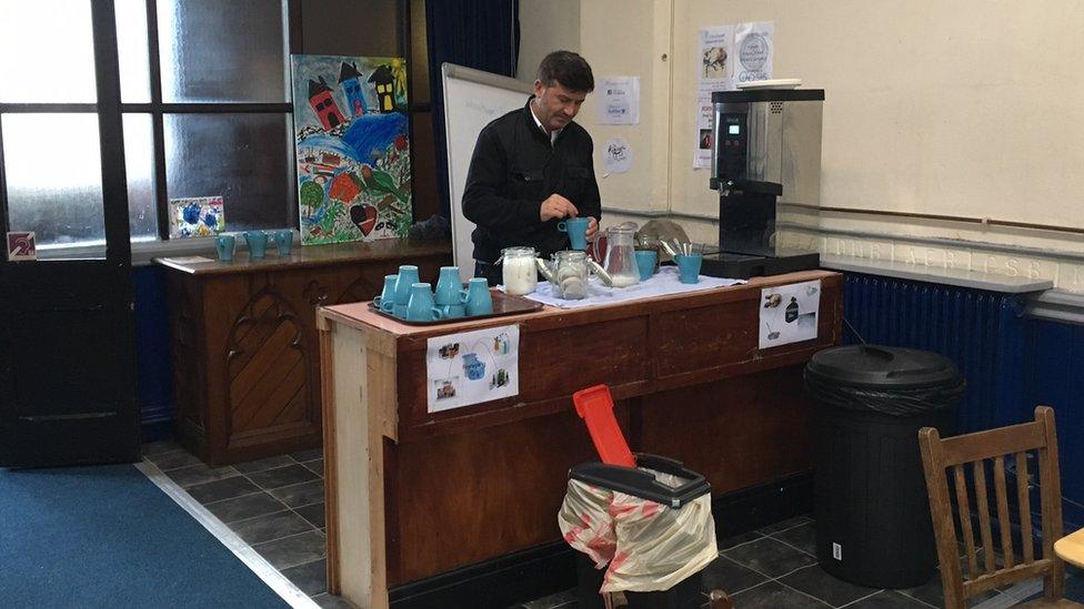 A man makes a cup of tea at the centre's cafe