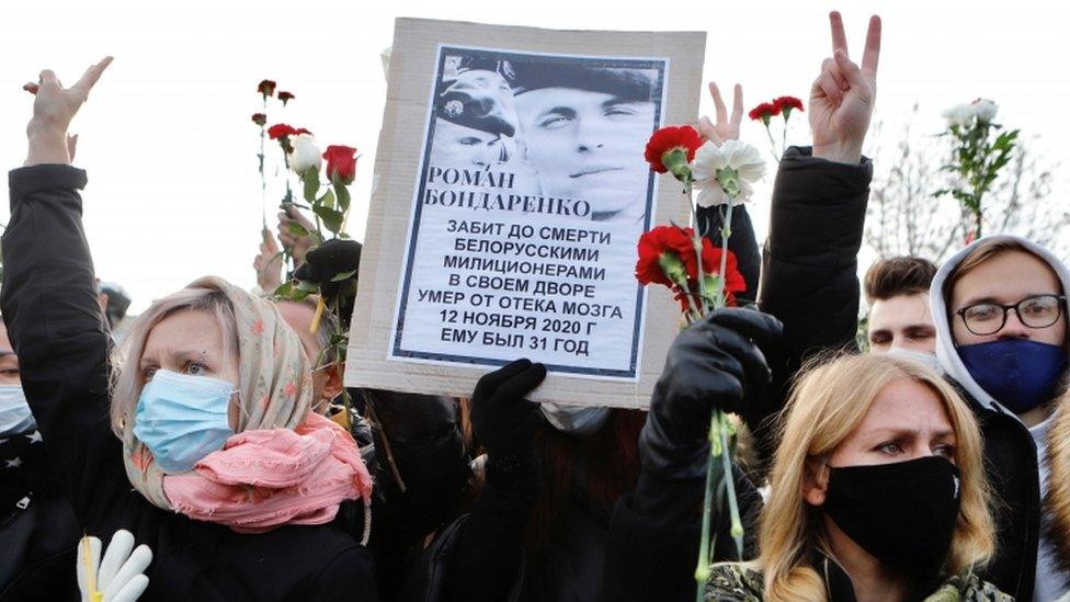 People hold a portrait of Roman Bondarenko, an anti-government protester who died in hospital following what witnesses said was a severe beating by security forces, during a memorial service in his honour, in Minsk, Belarus November 20, 2020