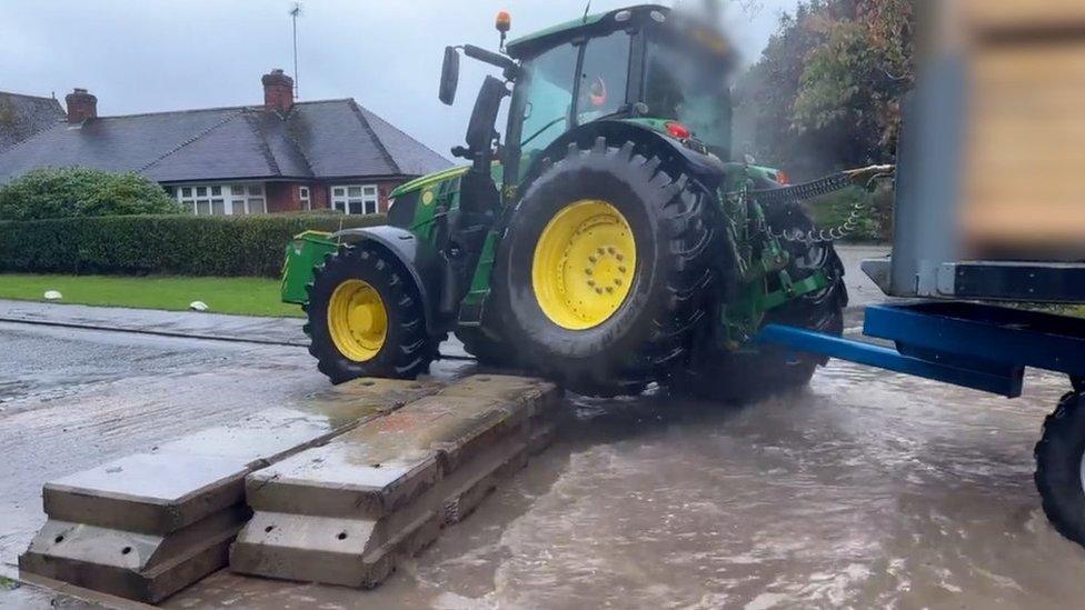 A tractor driving through Rufford Lane ford