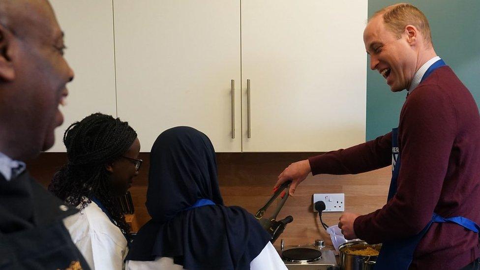 The Prince of Wales takes part in a cooking lesson during his visit to Together as One