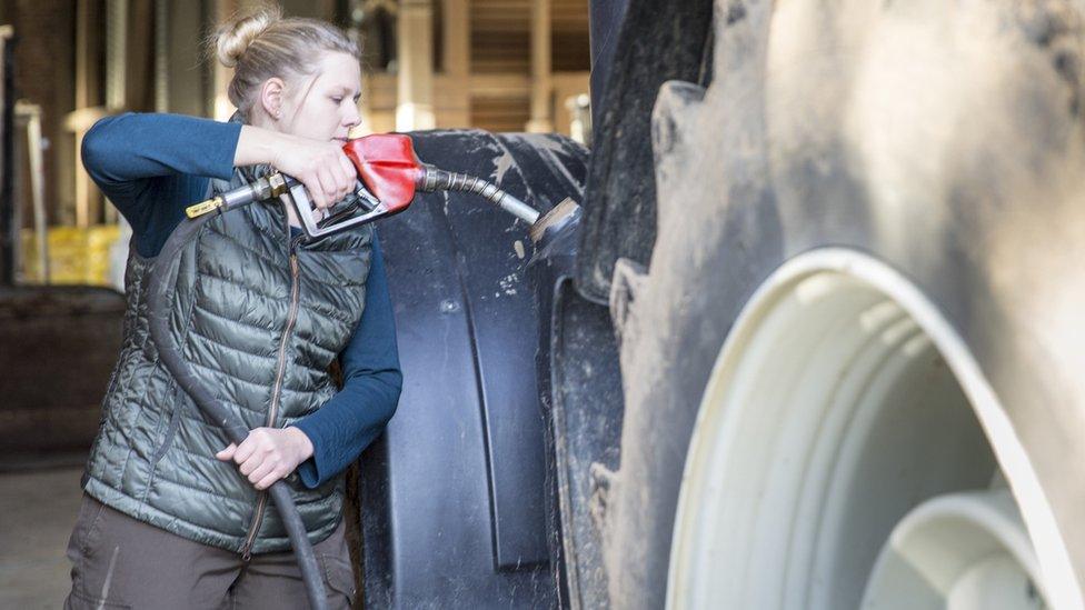 Farmer refuels tractor