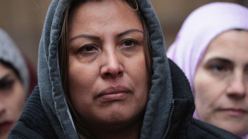 Francisca Lino listens as Rep. Luis Gutierrez speaks to the press after leaving the office of Immigration Services where he was briefly handcuffed and detained on 13 March, 2017 in Chicago