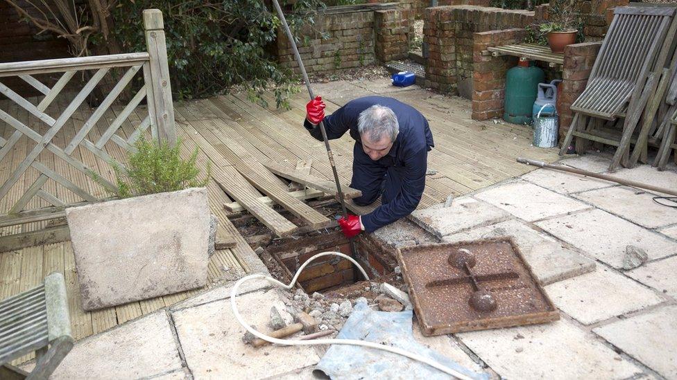 man clearing drain