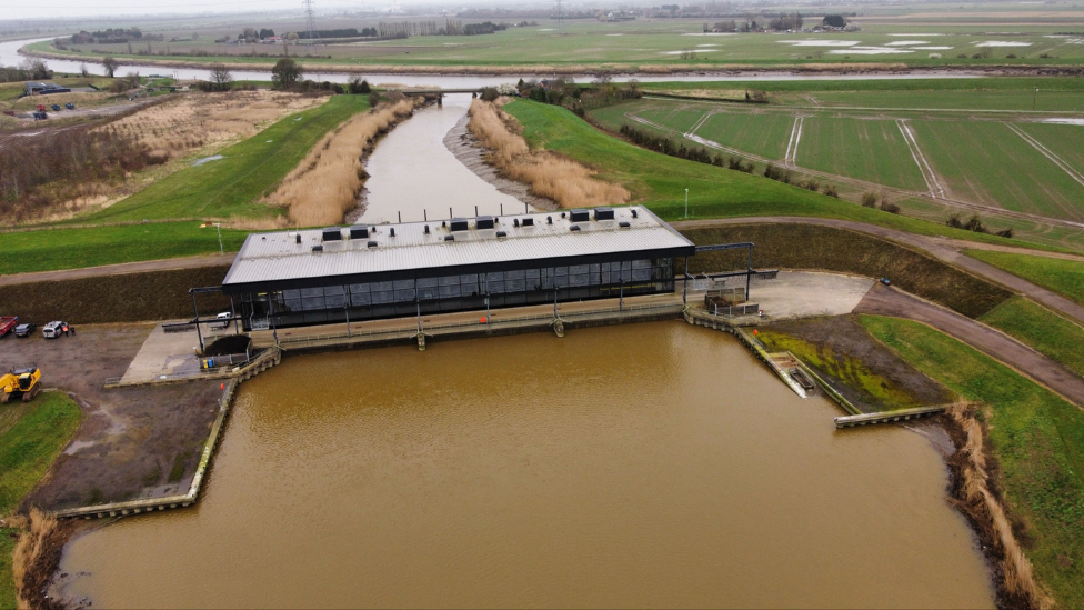 St Germans Pumping Station set over a large body of water and surrounded by fields