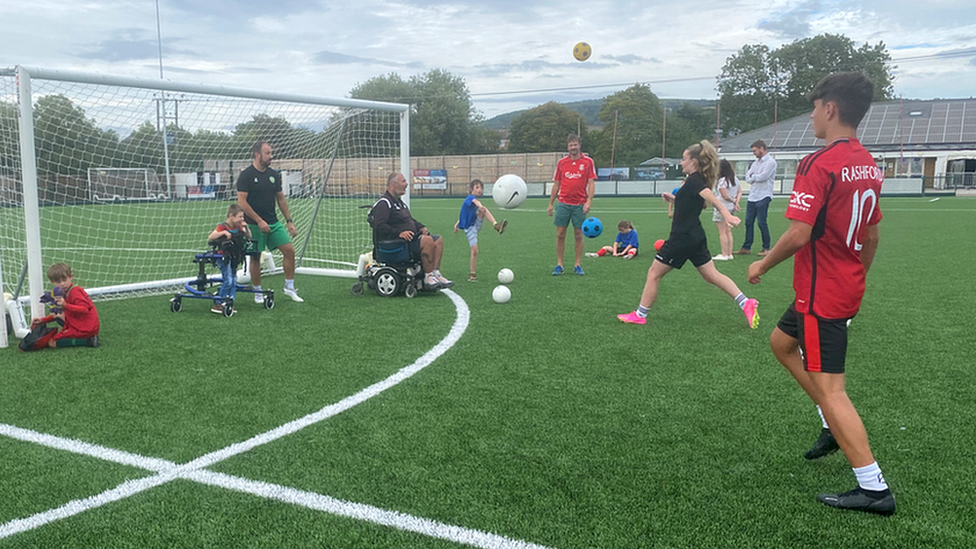 Children playing football and shooting at a goal