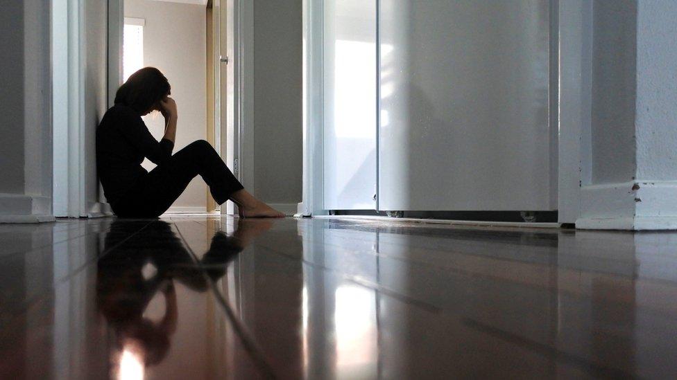 Woman sitting in her bedroom