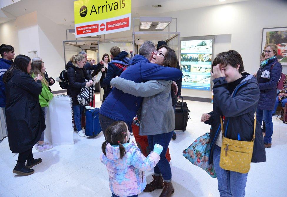 Relatives hug as they are reunited at Belfast City Airport