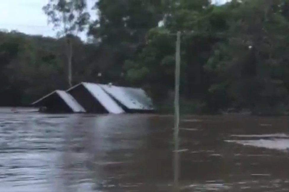 A house being swept away by floodwaters in Australia