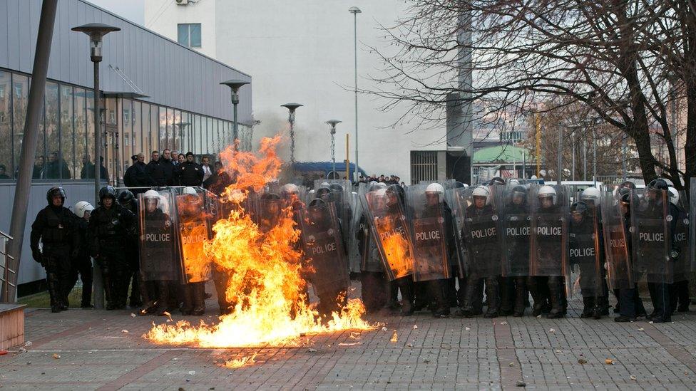 Pristina police in front of a fire caused by a petrol bomb (9 January)