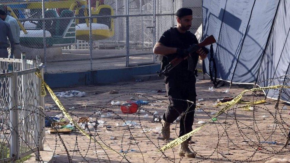 A Pakistani police commando walks at the cordoned-off site of the March 27 suicide bombing, in Lahore on March 28, 2016.