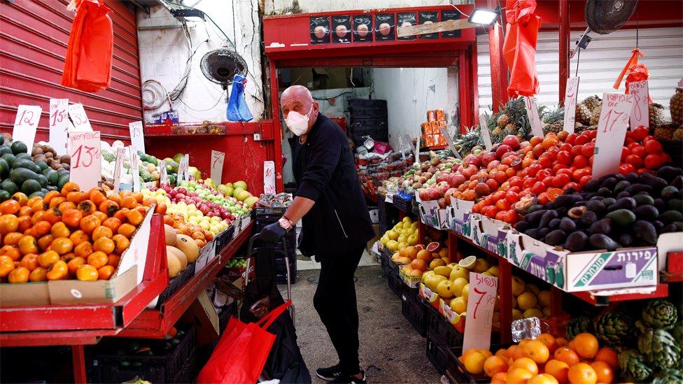 A man wearing a mask at a food shop in Tel Aviv (15 March 2020)