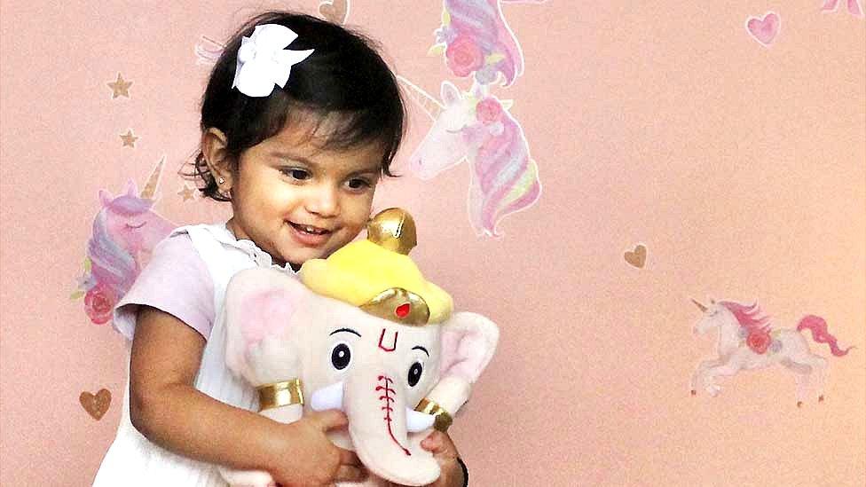 Girl with soft toy of the elephant-headed Hindu god Ganesha