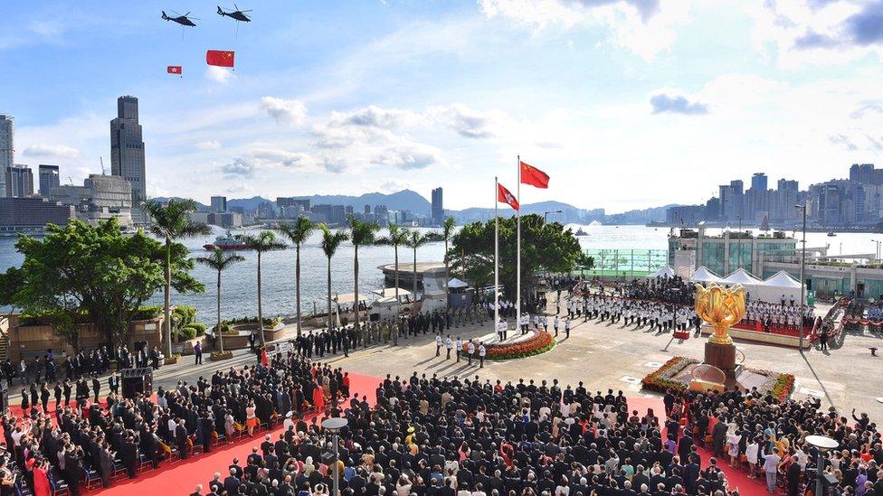 The China and Hong Kong flags are flown past by helicopters during a ceremony at Golden Bauhinia Square in Hong Kong, 1 July 2017