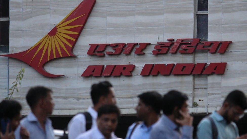 People walk past an Air India logo outside its building in Mumbai, India on 28 January 2020