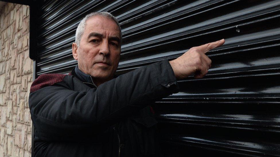 Pat Sheehan pointing at damage caused by a shot fired at a Sinn Fein office