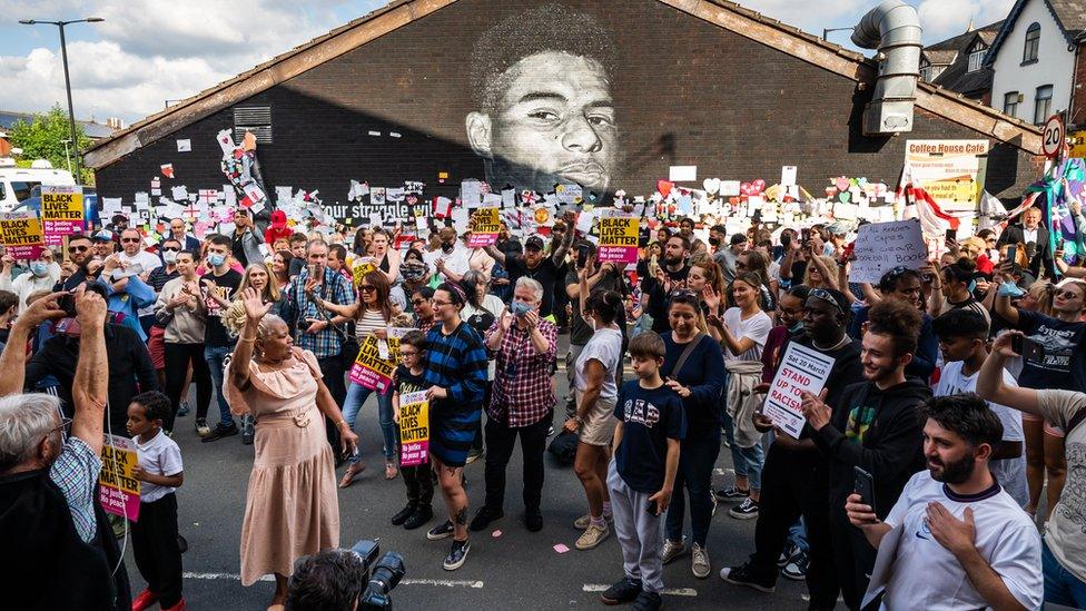 Crowd in front of mural of Marcus Rashford