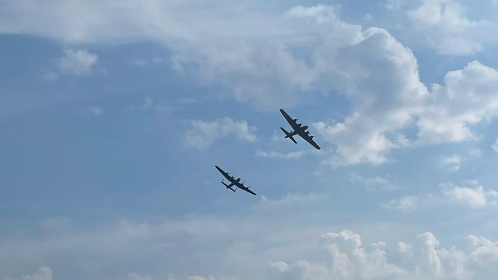 Planes in formation in a mostly cloudless sky.