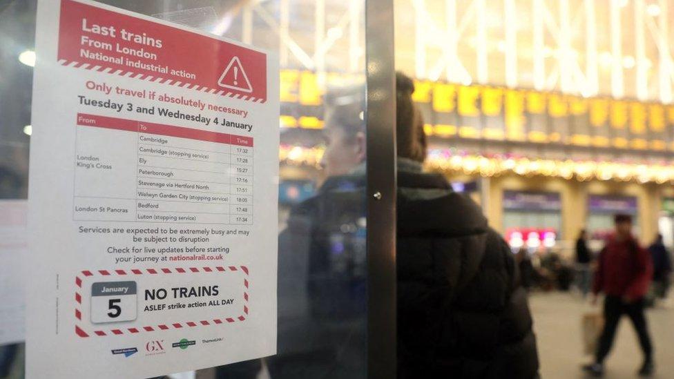 sign-behind-woman-waiting-for-train.