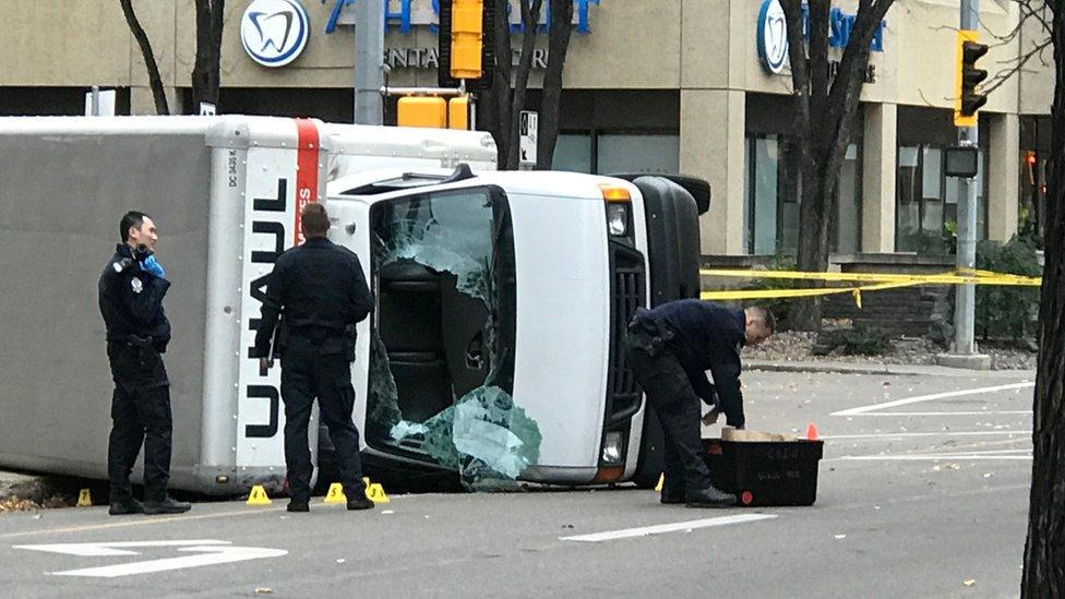 Edmonton Police investigate at the scene where a man hit pedestrians then flipped the U-Haul truck he was driving