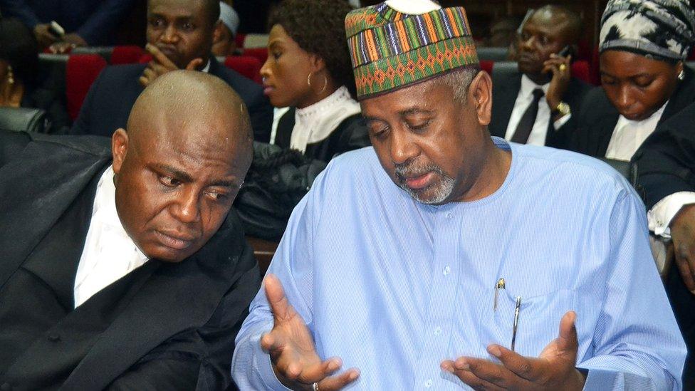 Former national security adviser of ex-president Goodluck Jonathan, Sambo Dasuki (R), speaks with his lawyer Ahmed Raji, during his trial at the federal high court in Abuja,