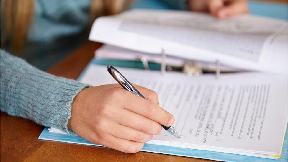 A hand writing in a folder