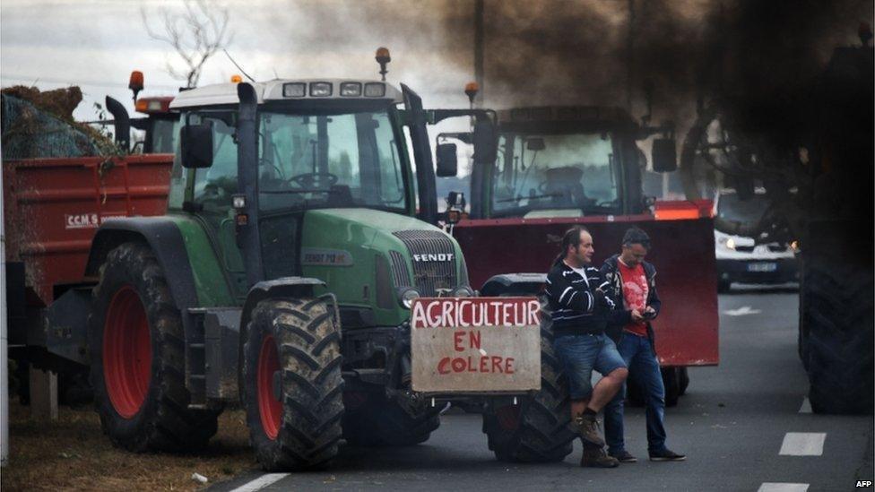 Farmers block Oleron bridge in western France (22 July) - placard reads "angry farmer"