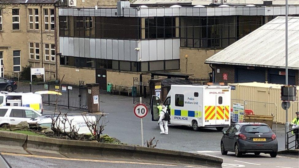 Police vehicles and officers in front of a building