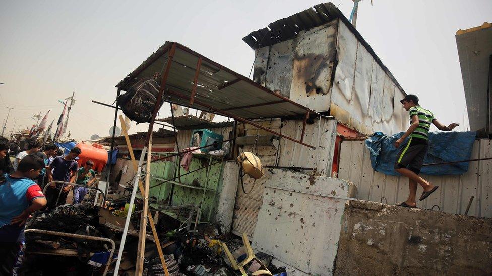 A boy inspects damage to marketplace damaged in car bombing in Sadr City, Baghdad (11 May 2016)