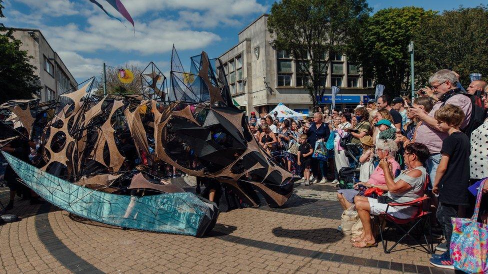 Crowds gather to see the dragon puppet