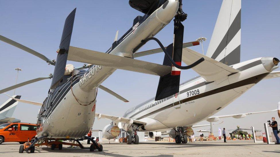 A Kazan Ansat light multirole helicopter (L) stands next to a Sukhoi Superjet 100 regional jet