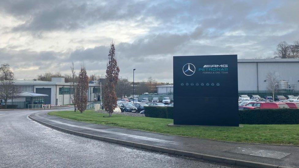 Industrial buildings and car park behind a Mercedes-AMG sign