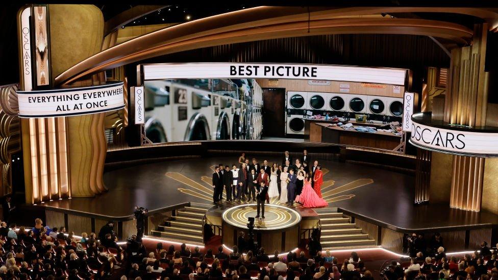 the cast and crew of everything everywhere all at once on stage receiving the best picture award