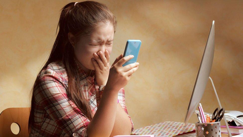 A young girl upset by something she has seen online