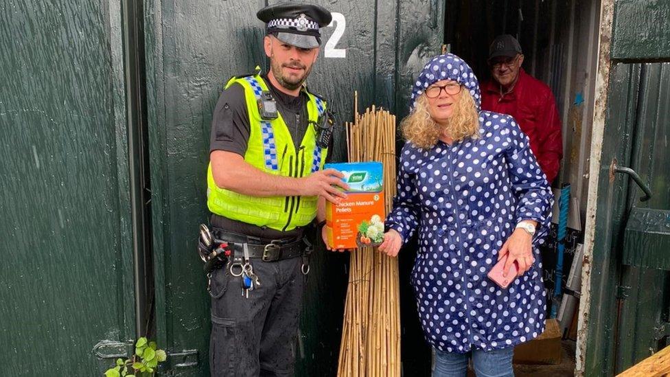 PC Stewart handing over manure to a community project