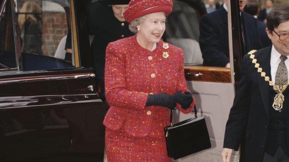 Queen in red with her black bag