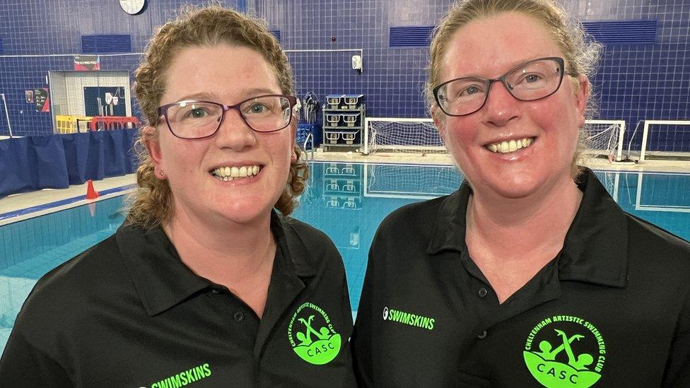 Sam Fancourt and Sarah Pullan stood in front of a swimming pool, smiling