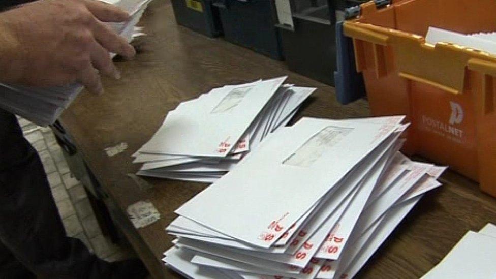 Postal worker sorting exam result envelopes