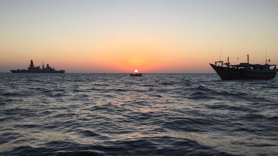 HMS Dragon in the background with the dhow in the foreground