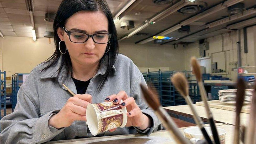 Emma Dudley hand-painting a cup