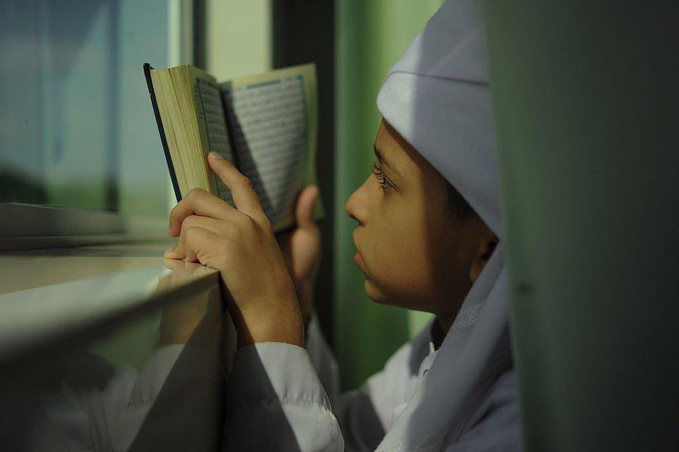 A Malaysian Muslim boy reads a copy of the Koran at his school's mosque during the holy fasting month of Ramadan in Bentong, outside Kuala Lumpur on 15 June 2016.