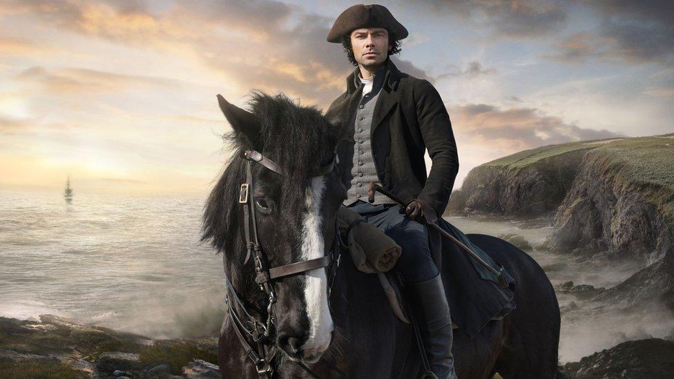 Poldark star Aidan Turner sits on a horse in a promotional photo for the drama