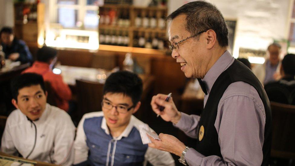 Elderly worker serving customers at Gingko House in Hong Kong