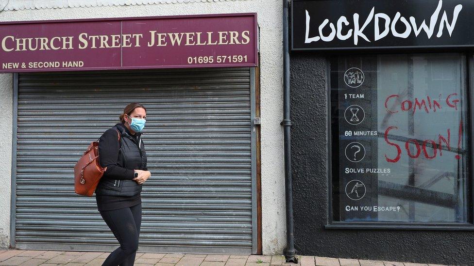 Woman walking outside a closed-up shop