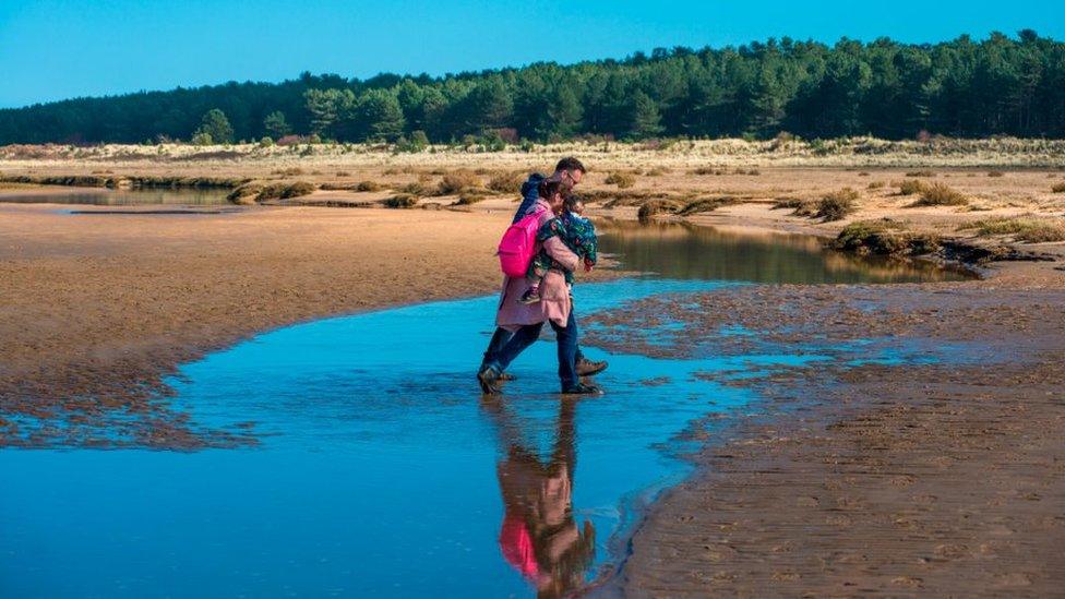 People walk on Norfolk beach