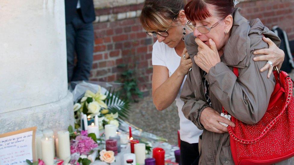 Women reacts at memorial for priest